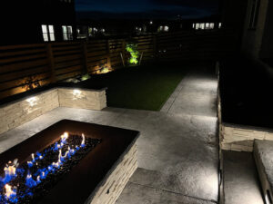 Modern patio at night with a stone fire pit
