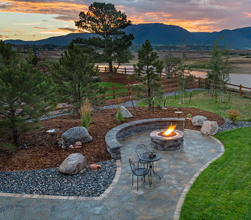 hardscape patio with fire pit in front of mountain sunset